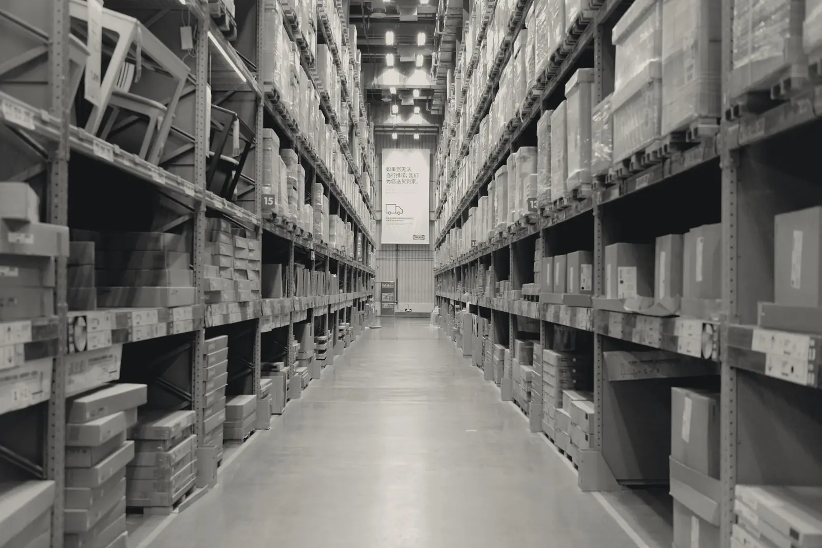 A long warehouse aisle lined with stocked racking